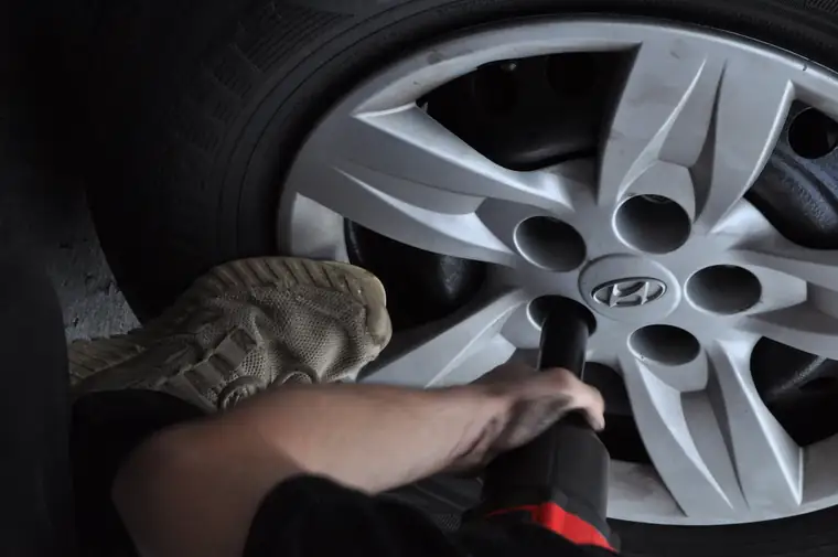 Technician changing a flat tyre at the roadside