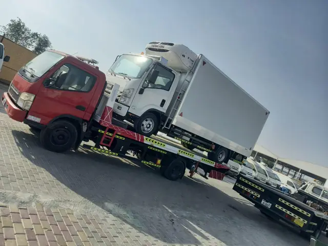 Flatbed recovery truck carrying a refrigerated lorry — MZ Meer Car Recovery