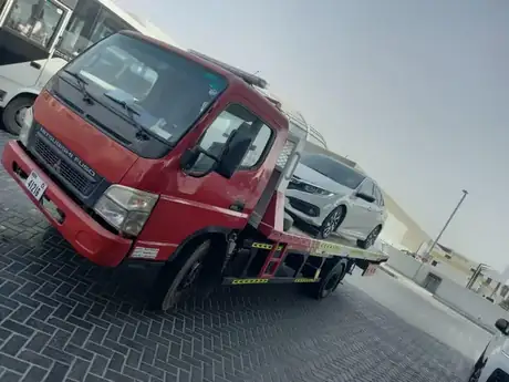 Red recovery truck with a saloon car loaded on the bed — MZ Meer Car Recovery