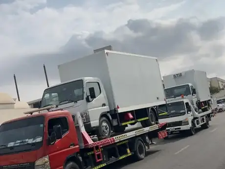 Two recovery trucks on a UAE road — MZ Meer Car Recovery