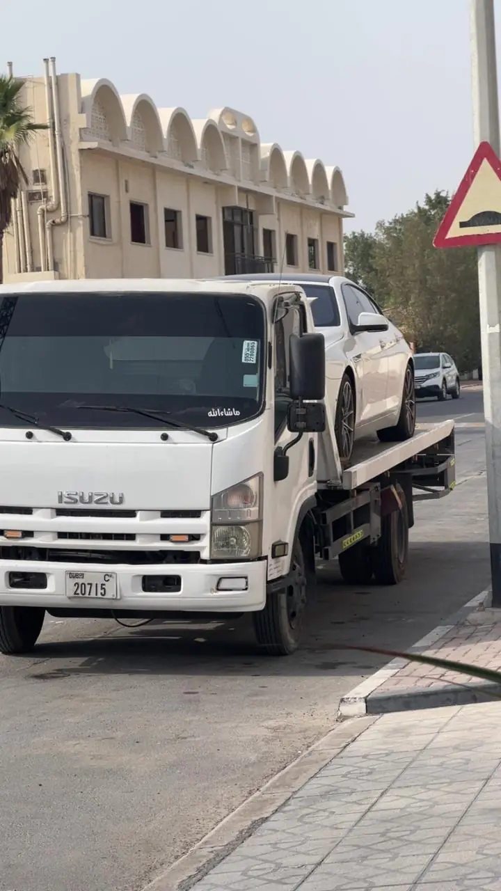 Broken-down pickup loaded on an MZ Meer recovery truck in Dubai